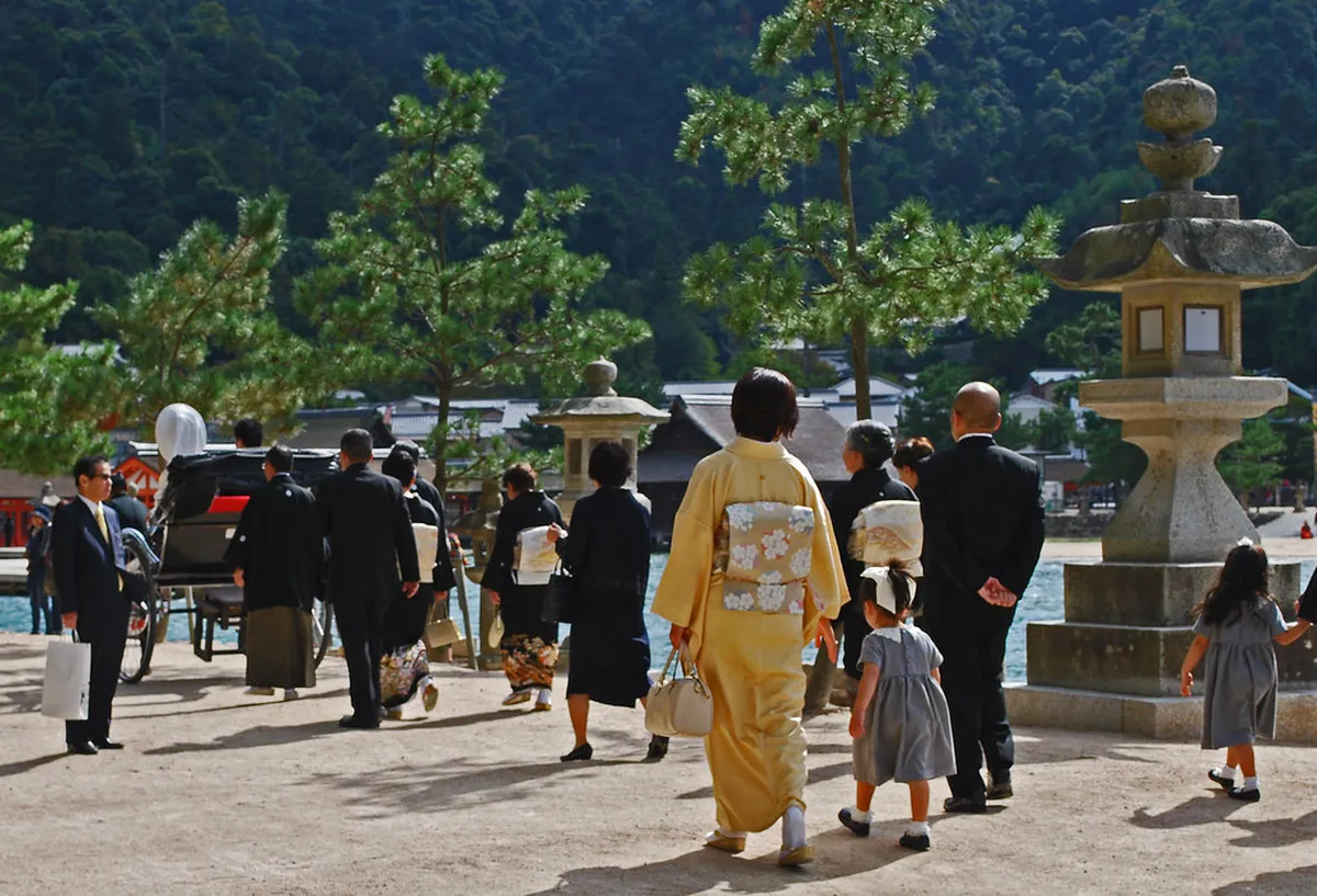 Miyajima Island deer and torii gate shoreline with mountains in the background in Hiroshima, Japan