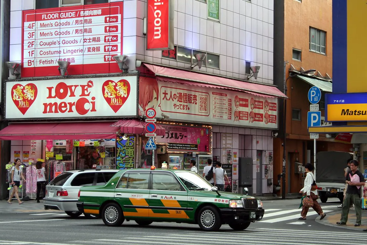 Neon-lit anime and electronics shop fronts along the main street of Akihabara in Tokyo Japan