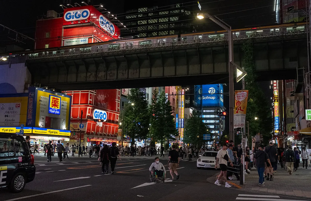 Colorful neon signs and illuminated storefronts lighting up Akihabara streets at night in Tokyo Japan