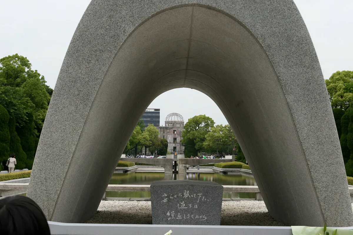 Hiroshima cenotaph arch and the eternal Peace Flame burning in front of the Atomic Bomb Dome, Japan