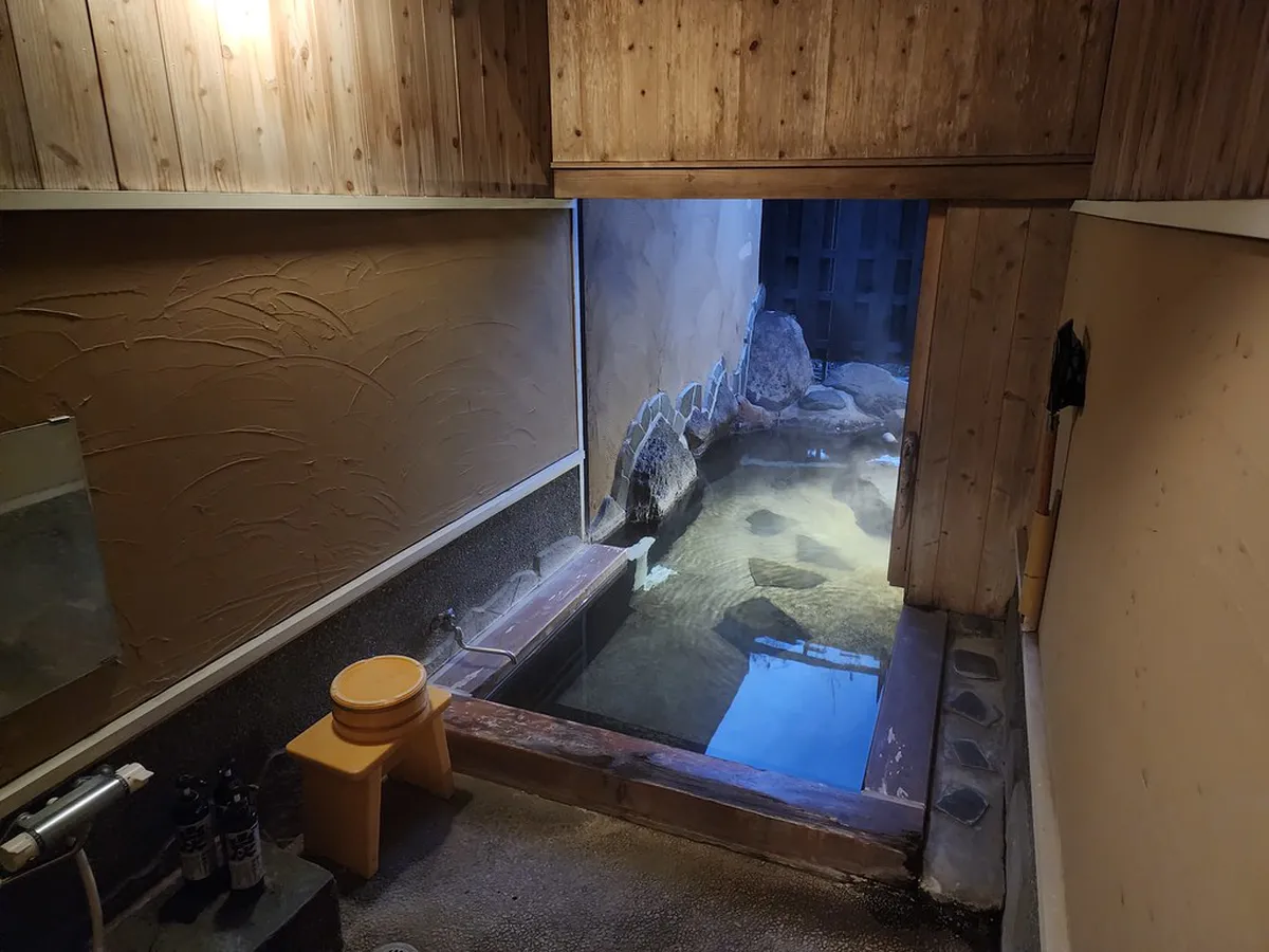 Traditional Japanese ryokan courtyard garden in Beppu with wooden architecture and serene onsen atmosphere