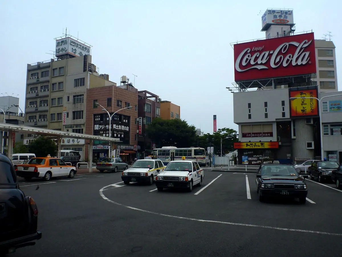 Beppu Station street area with modern buildings and local street vendors in Oita