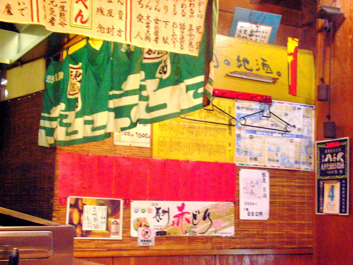 Traditional izakaya interior in Japan with wooden counter seating and warm lantern lighting