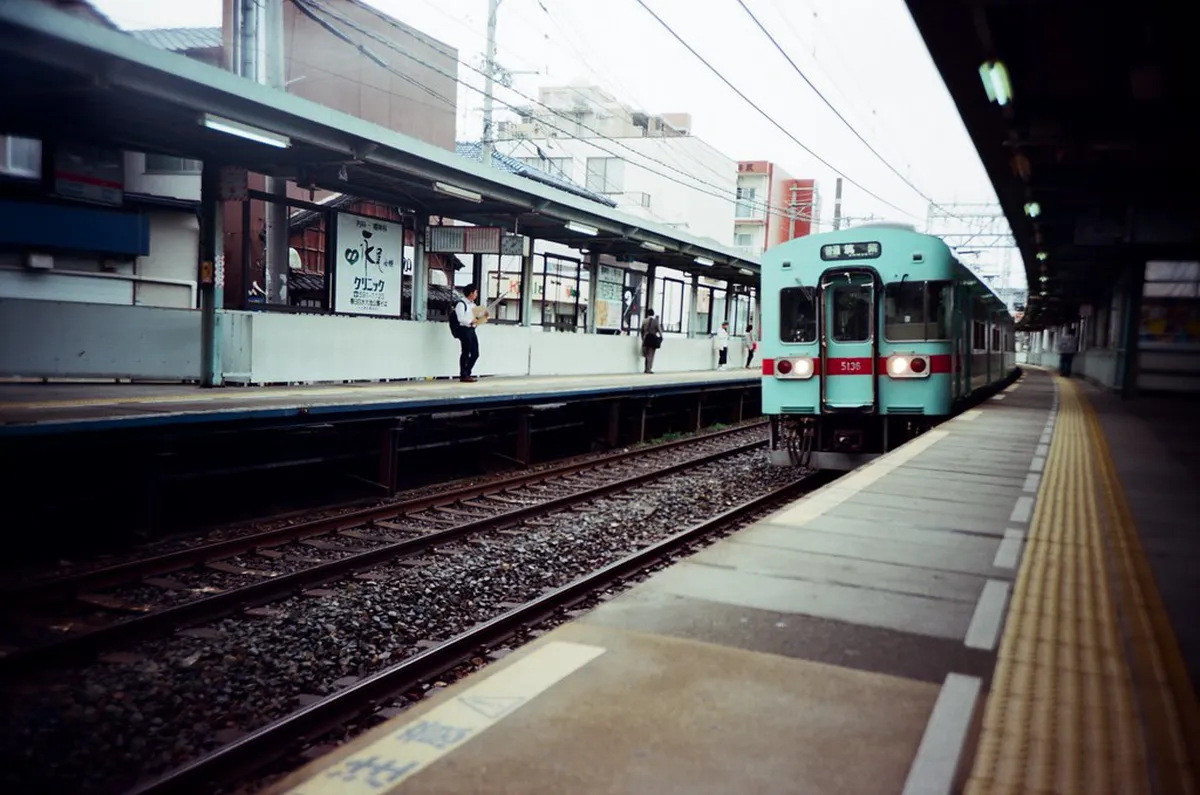 Fukuoka train platform with commuters heading out on a day trip to Dazaifu or Yanagawa, Japan