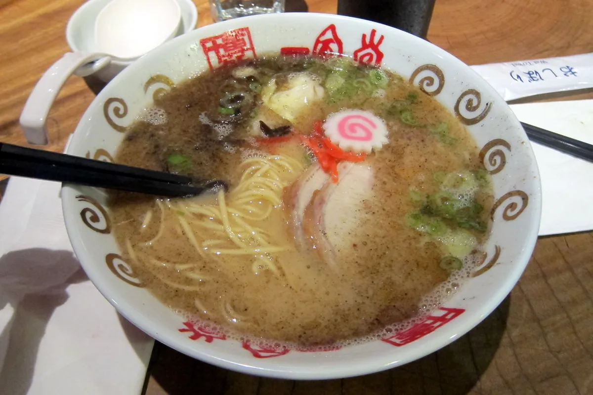 A steaming bowl of Hakata tonkotsu ramen with rich pork bone broth and thin noodles, a signature dish from Fukuoka, Japan