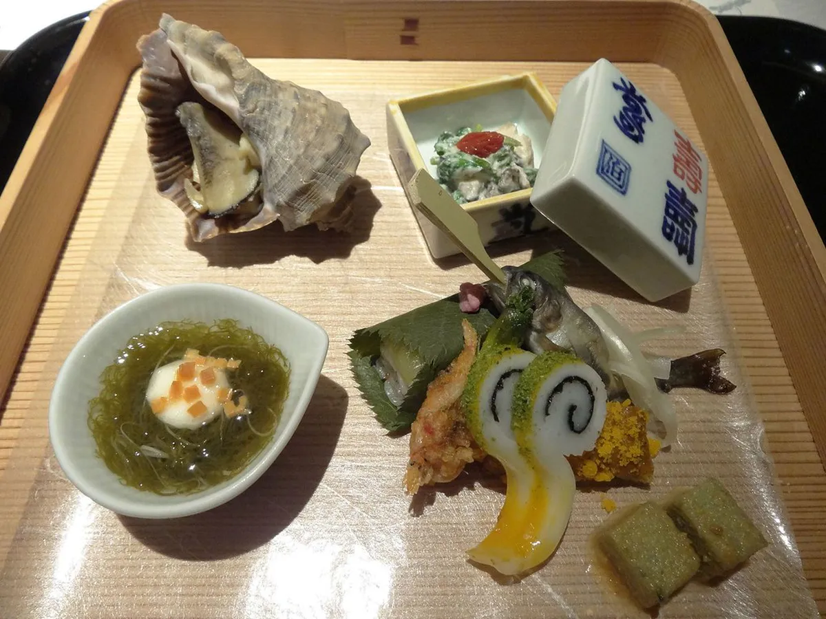 Elegantly plated Japanese kaiseki course meal with seasonal ingredients, reflecting the refined tradition of Kaga cuisine in Japan