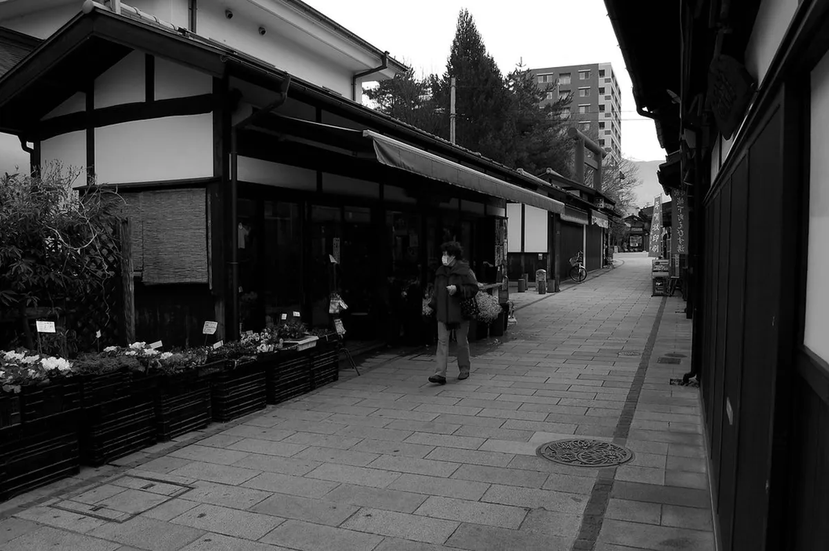 Nawate-dori pedestrian street lined with frog statues and shops along the river in Matsumoto, Japan