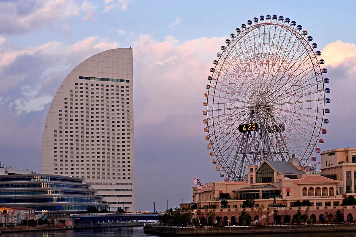 Cosmo Clock 21 Ferris wheel lit up at night in Yokohama reflecting on the harbor water below