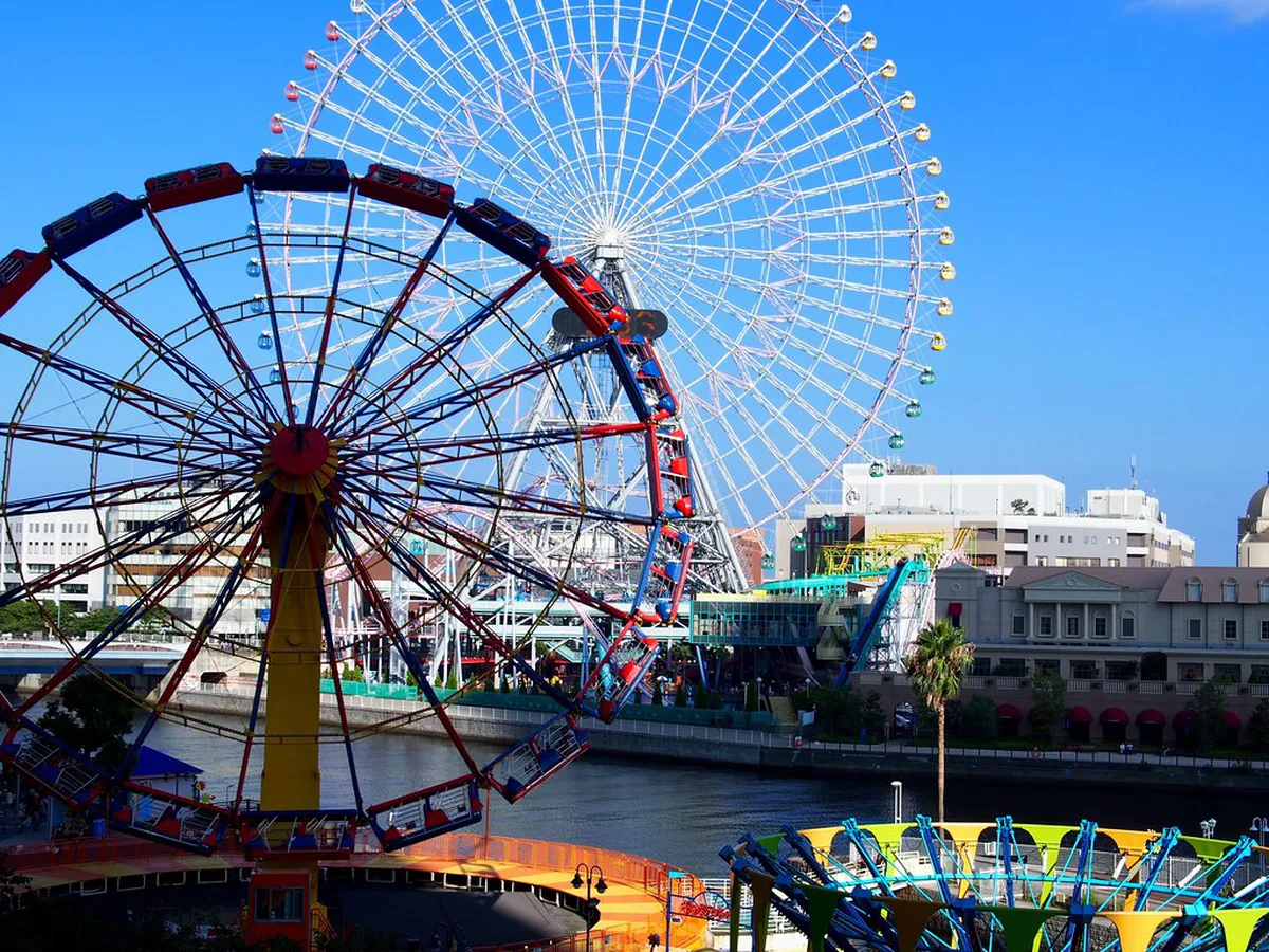 Yokohama Cosmo World amusement park in Minato Mirai with rides and the illuminated Cosmo Clock 21 Ferris wheel