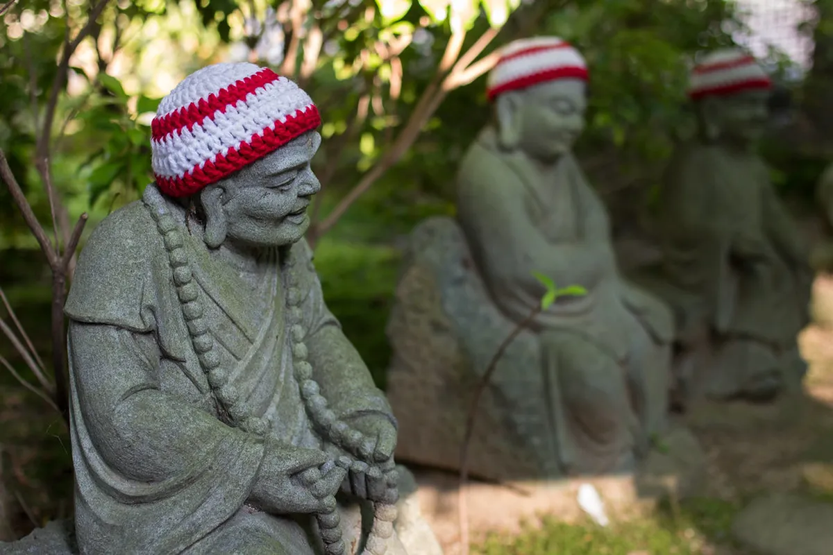 Rows of 500 Rakan stone statues with unique expressions along the path at Daisho-in temple Miyajima Japan