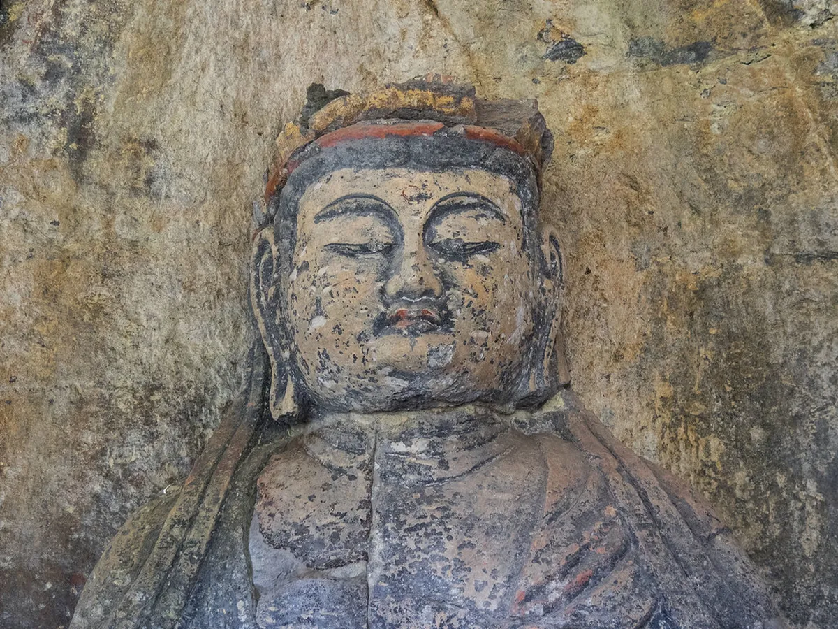 Ancient Usuki stone Buddha carving in cliff face with intricate sculptural detail from medieval Japan