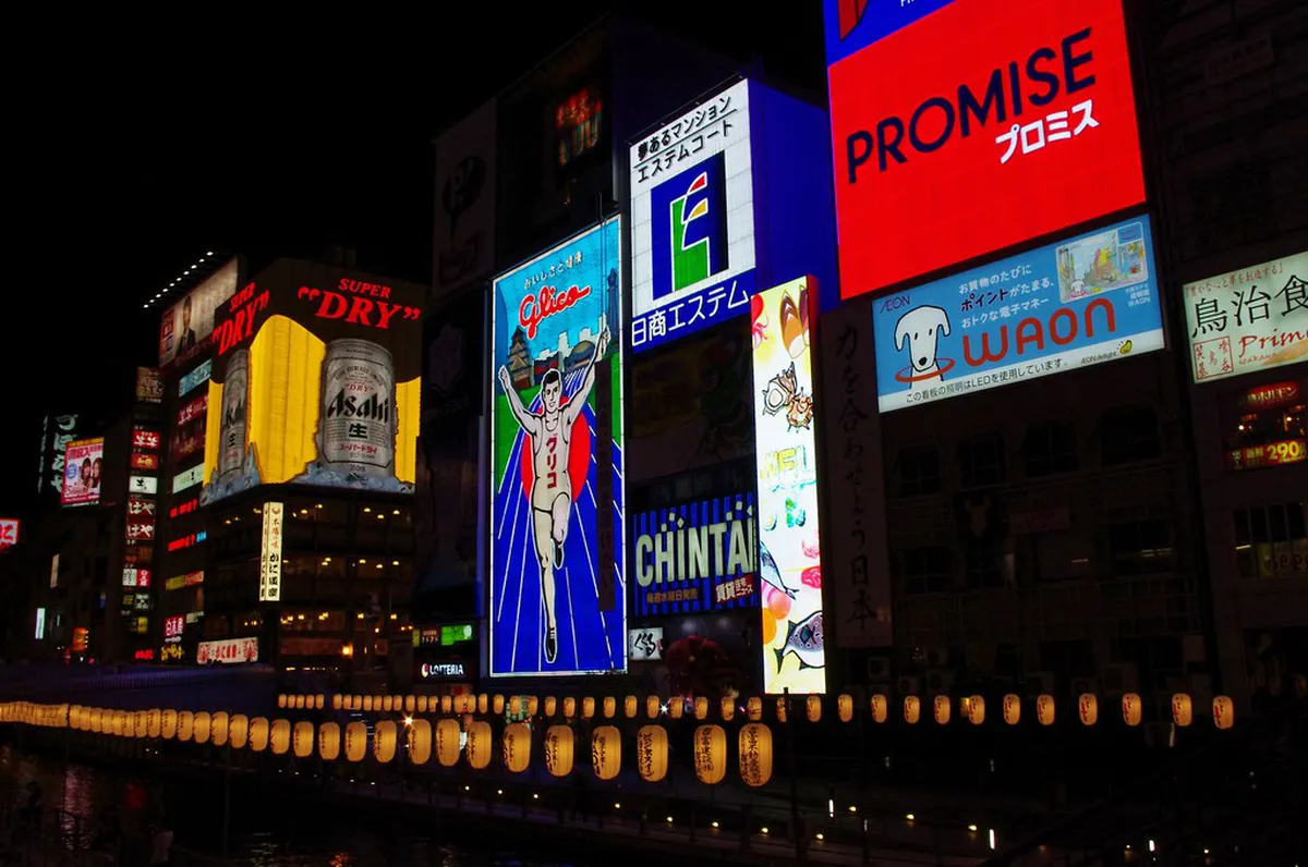 The iconic Glico Running Man illuminated sign above Ebisubashi Bridge in Dotonbori, Osaka Japan