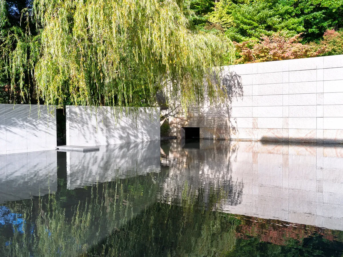 The tranquil water mirror garden at the D.T. Suzuki Museum in Kanazawa reflecting the surrounding concrete walls and sky