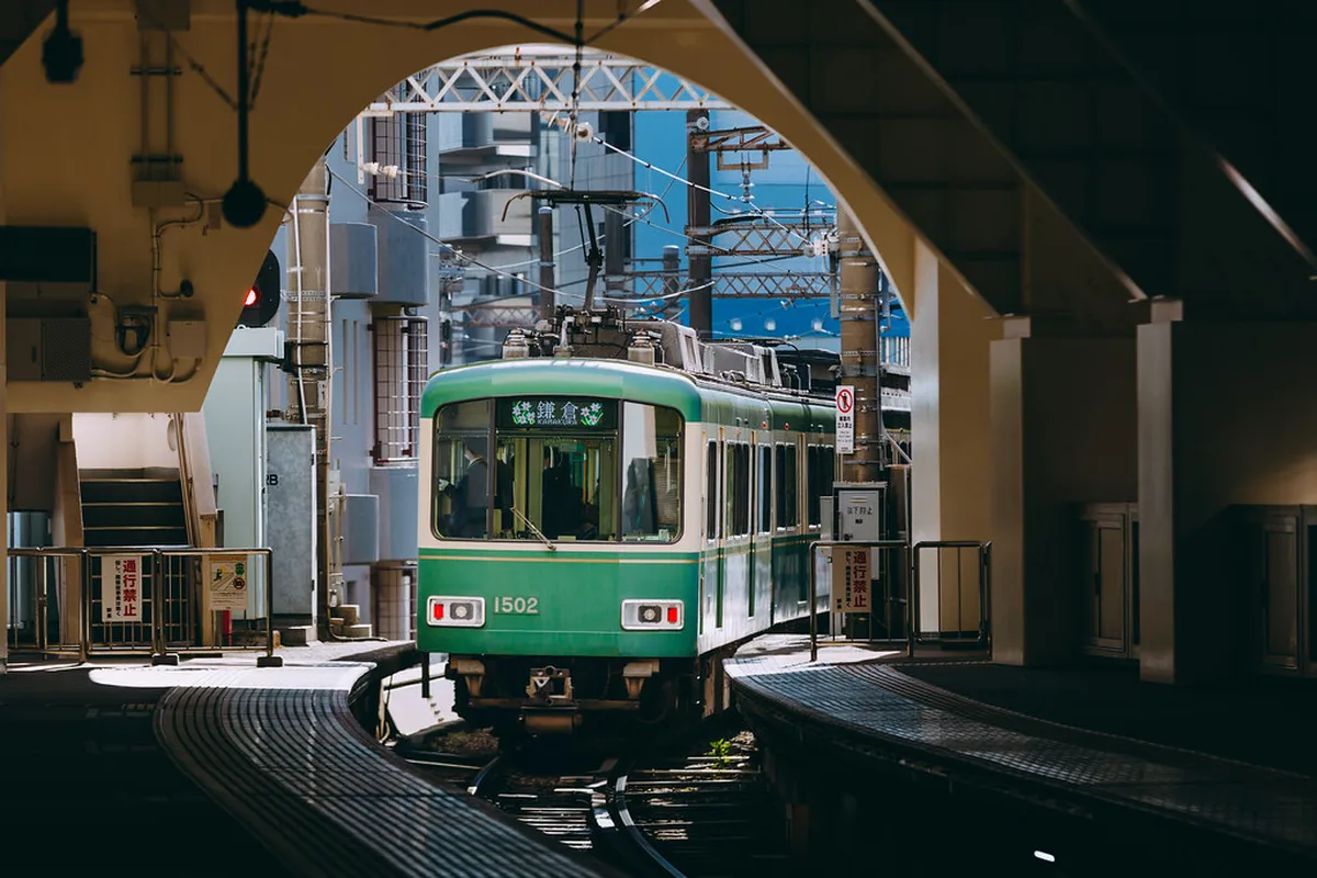 The vintage Enoden tram winding through narrow streets between Kamakura and Enoshima in Japan