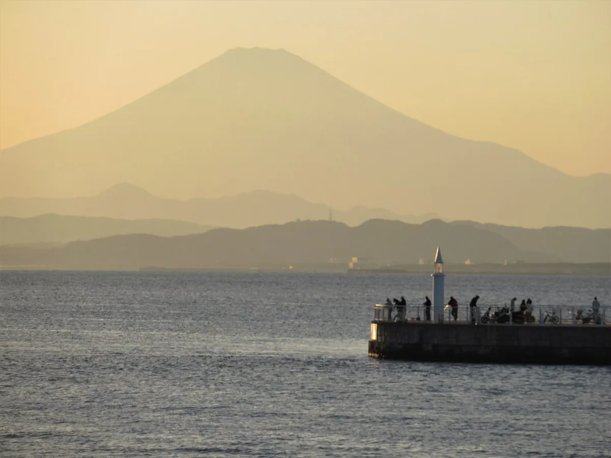 Enoshima Sea Candle lighthouse tower rising above the island gardens at sunset near Kamakura Japan