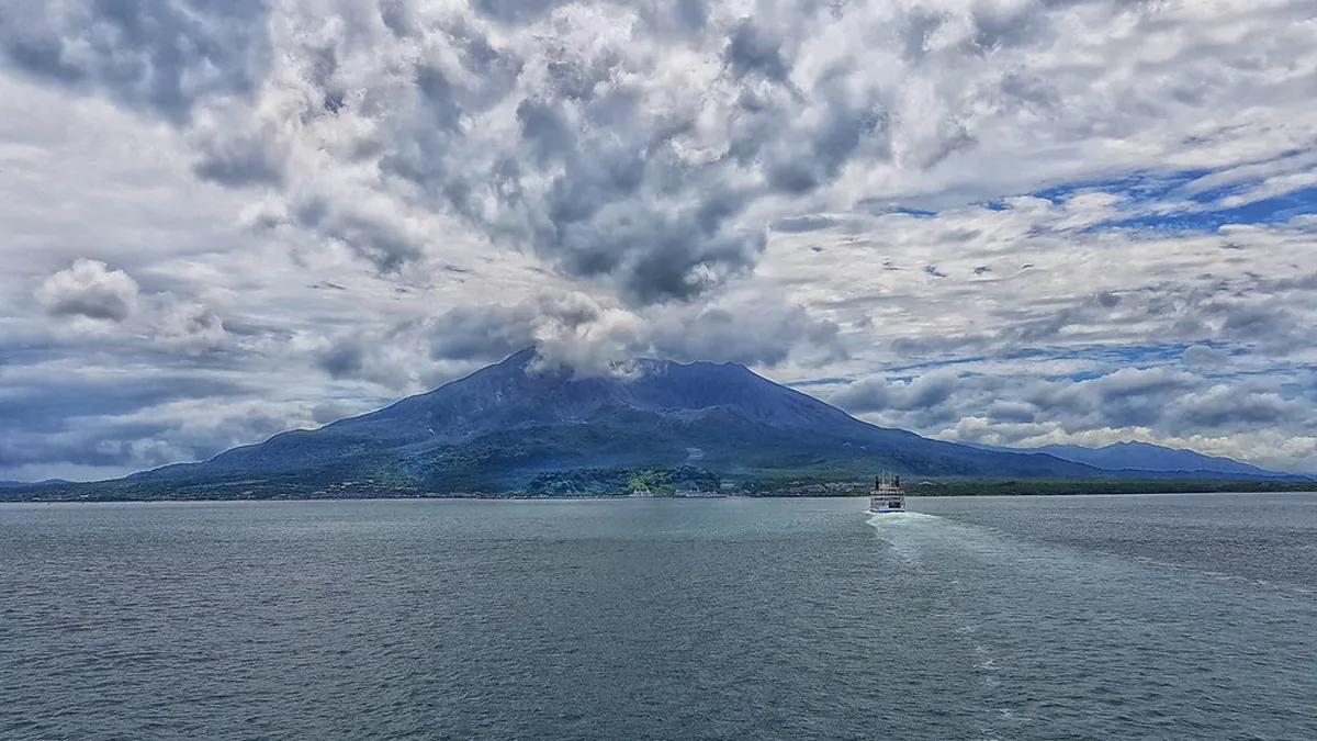 Sakurajima active volcano rising above Kagoshima Bay with a clear view from the city waterfront in Japan