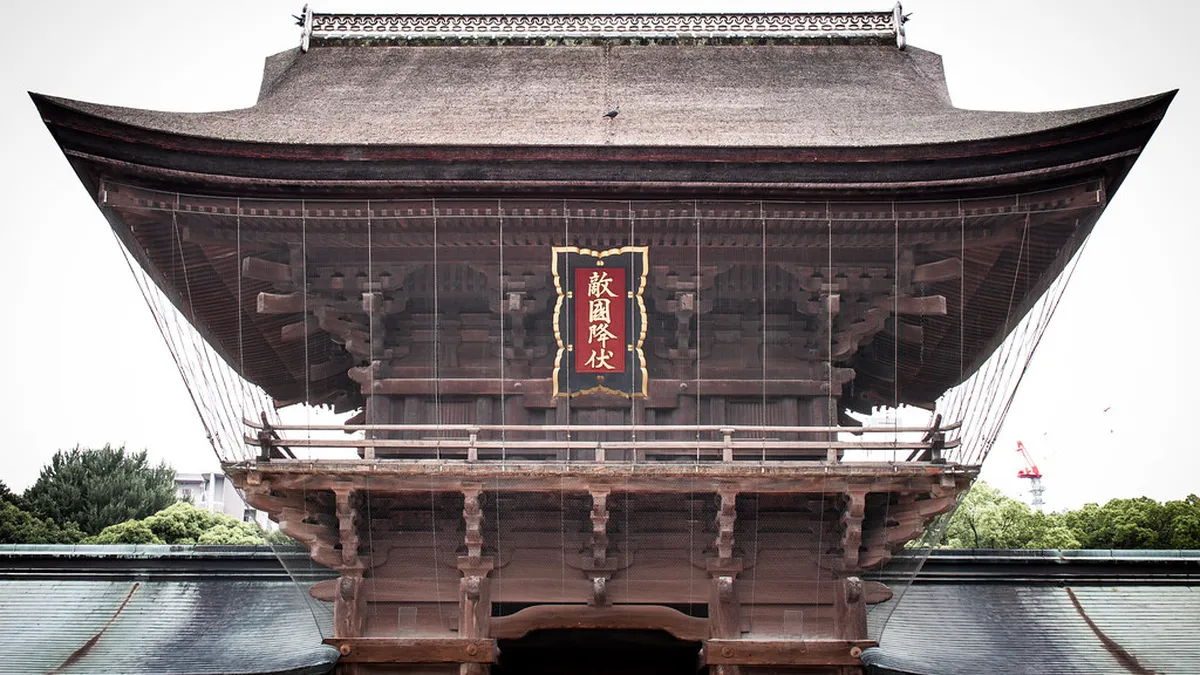 The vermilion torii gates and stone lanterns lining the path to Hakozaki Shrine in Fukuoka Japan
