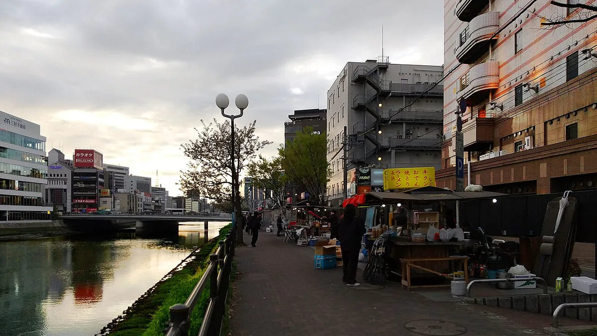 Row of illuminated yatai food stalls along the Naka River at night, Japan — 2
