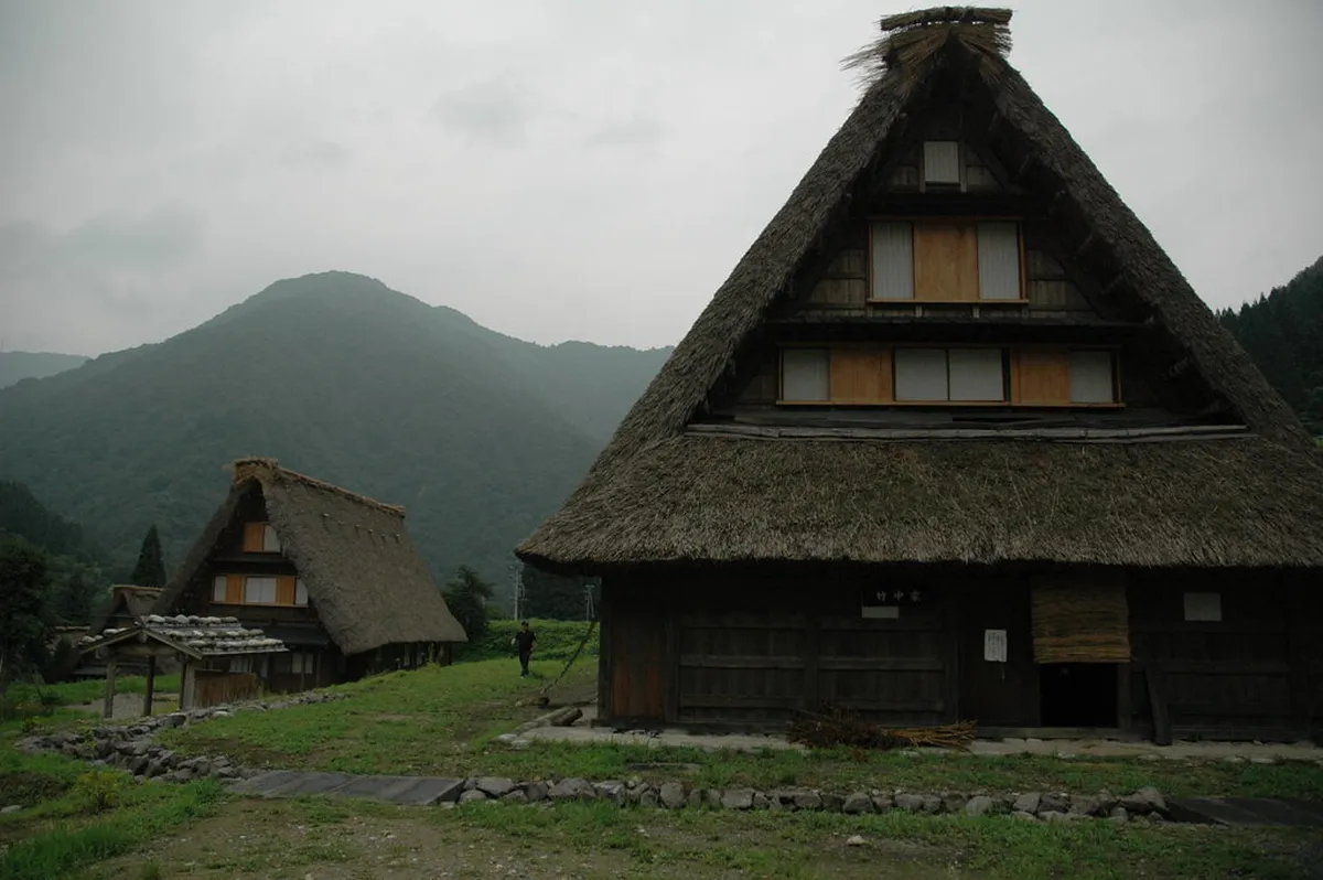 Traditional gassho-zukuri houses with steep thatched roofs in the Gokayama mountains, showcasing the unique architecture of this UNESCO heritage site