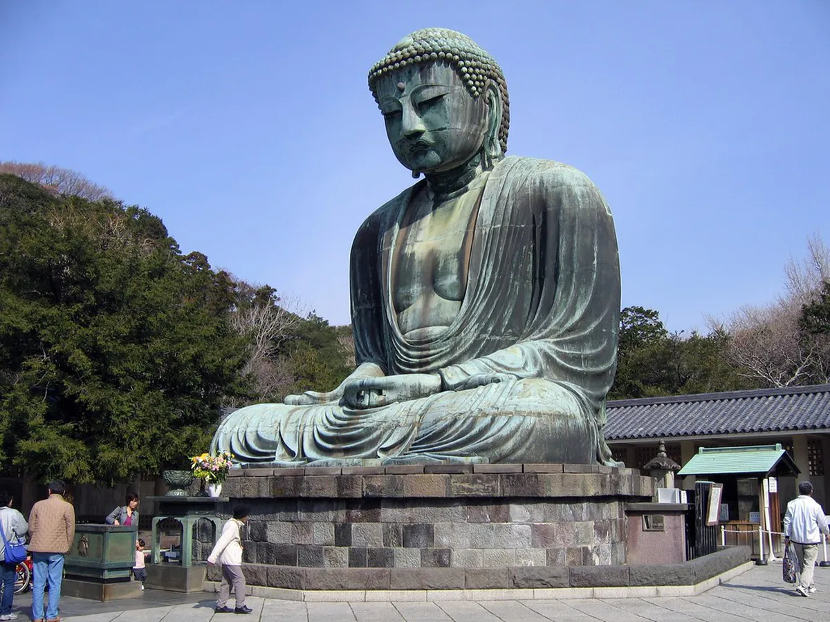 Close-up view of the bronze Kamakura Daibutsu statue showing casting seam lines and architectural details at Kotoku-in, Japan