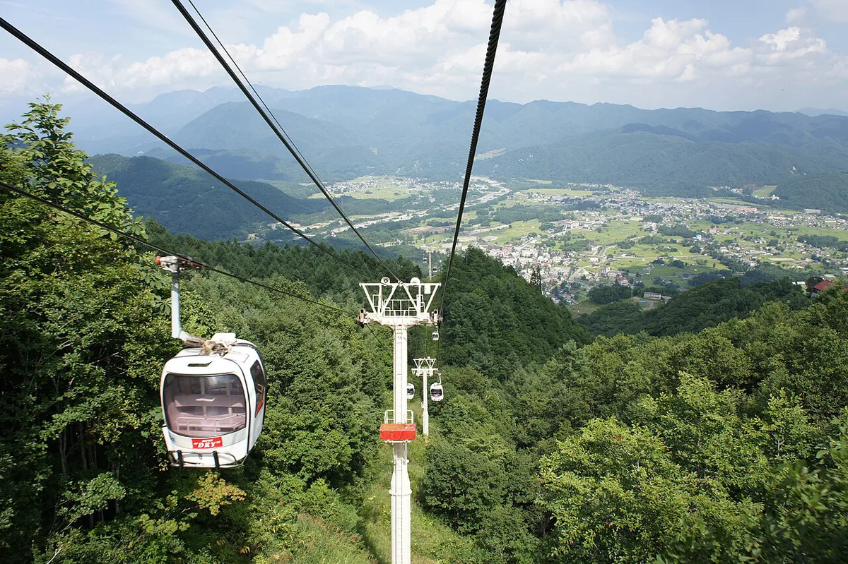 Gondola and ski slopes at Happo-One resort with Northern Alps backdrop, Japan — 1