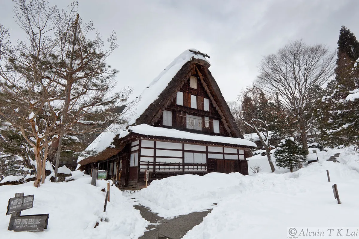 Traditional thatched farmhouses reflected in the pond at Hida Folk Village open-air museum in Takayama