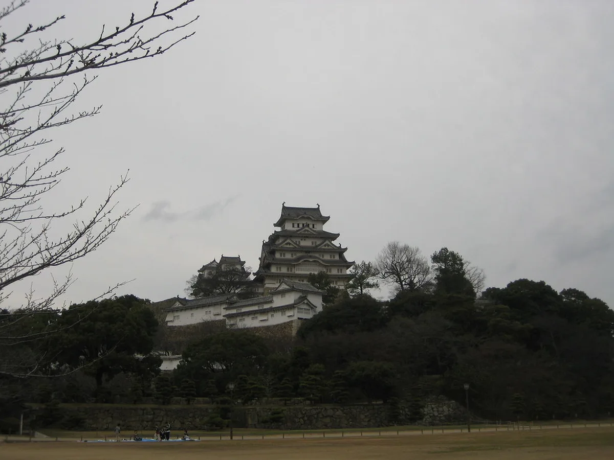 Visitors climbing the steep wooden stairs inside Himeji Castle's keep