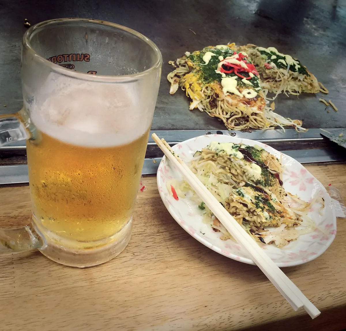 Freshly made Hiroshima-style okonomiyaki layered with noodles and egg served at a local restaurant in Japan
