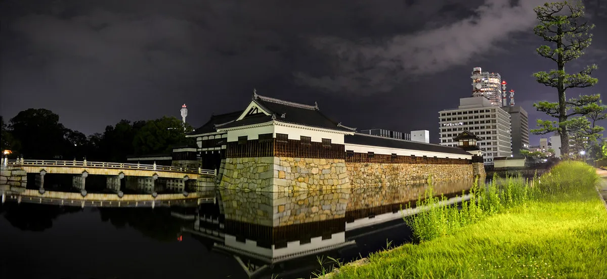 Hiroshima Castle Ninomaru gate and traditional timber structures reflected in the inner moat, Japan