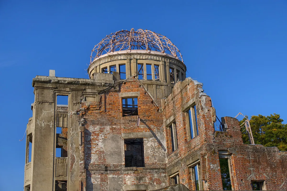 Hiroshima Peace Memorial Museum exterior with visitors and the iconic Atomic Bomb Dome in the background in Japan