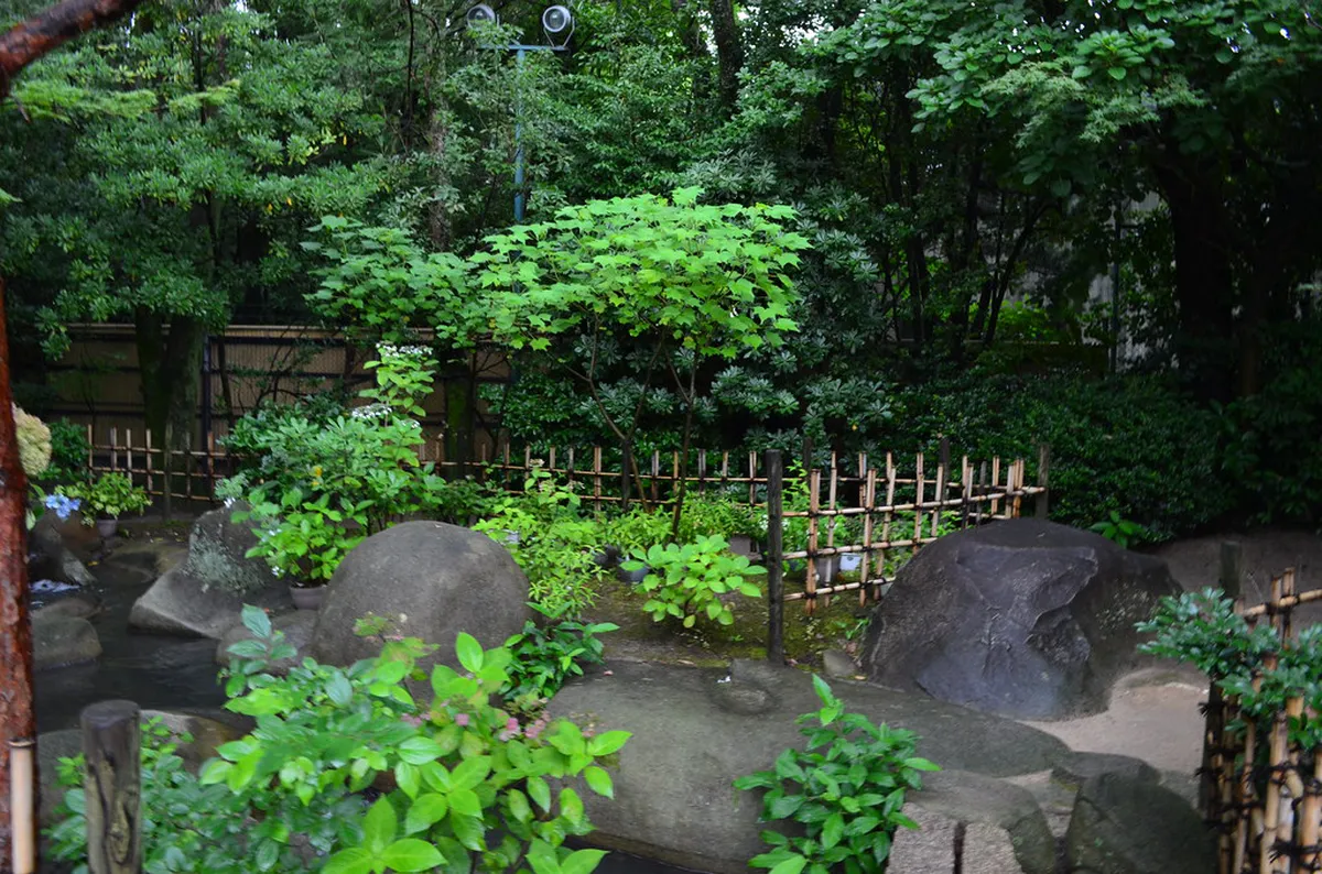 Shukkei-en garden koi pond with arched bridge and traditional pavilion in Hiroshima, Japan