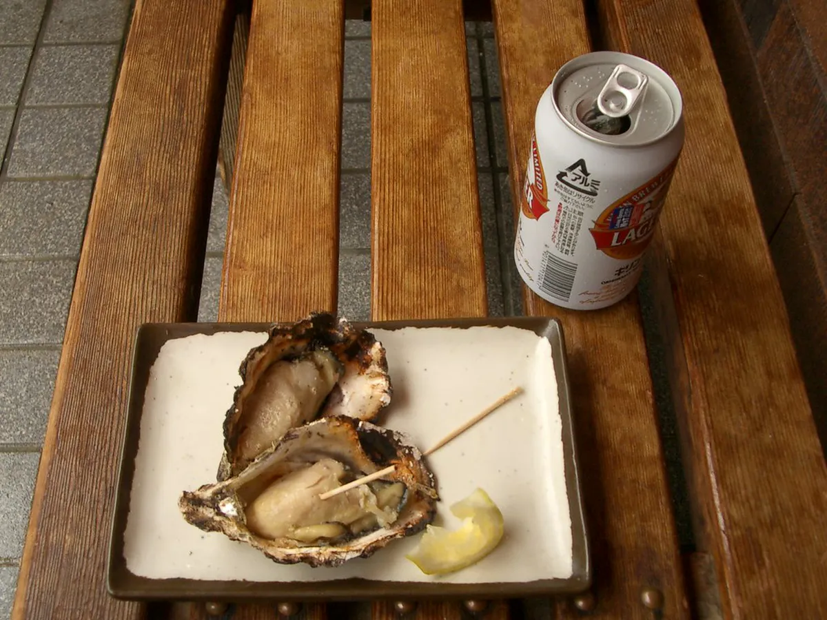 Fresh Hiroshima oysters on the half shell with lemon ready to eat at a late-night bar in Hiroshima, Japan
