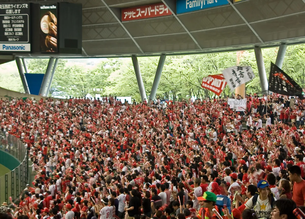 Hiroshima Carp baseball fans in red jerseys celebrating in the city streets after a home game, Japan
