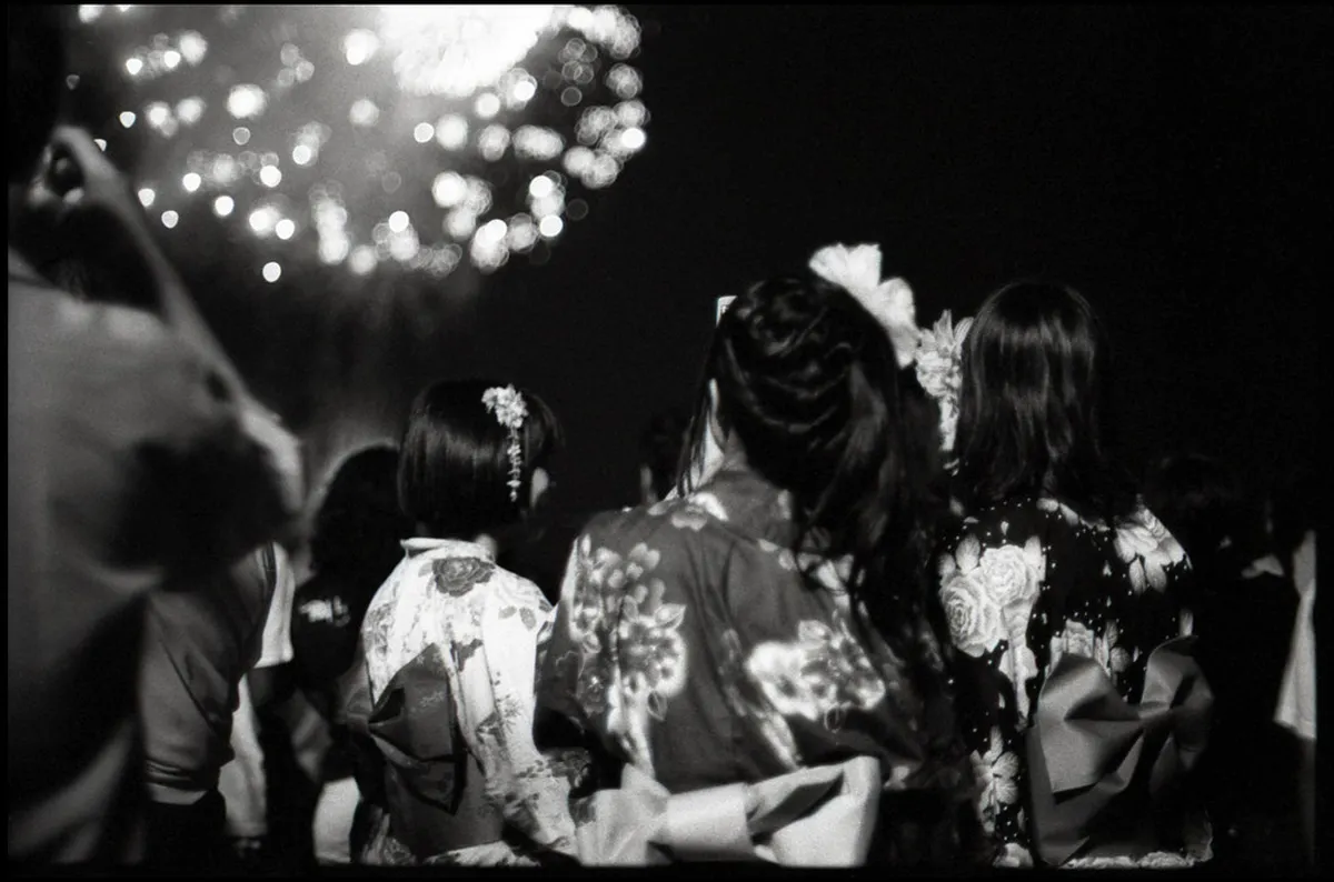 Jazz musicians performing on an outdoor stage during a festival in Japan with a lively crowd