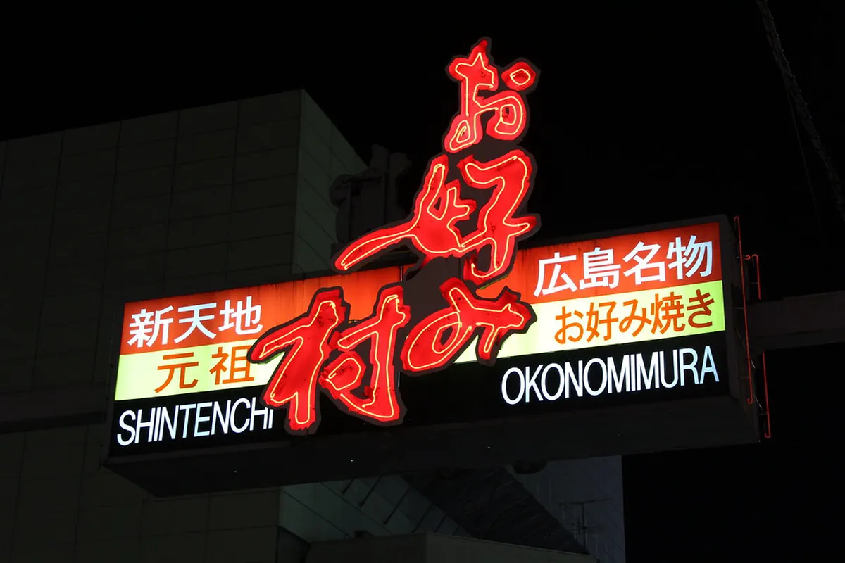 Okonomimura multi-story food building in the Shintenchi district of Hiroshima with vendors and visitors, Japan