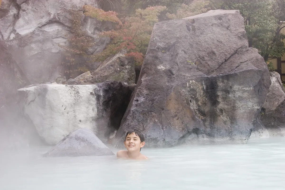 Steam rising from geothermal hot spring pools at a Beppu onsen venue in Oita, Japan