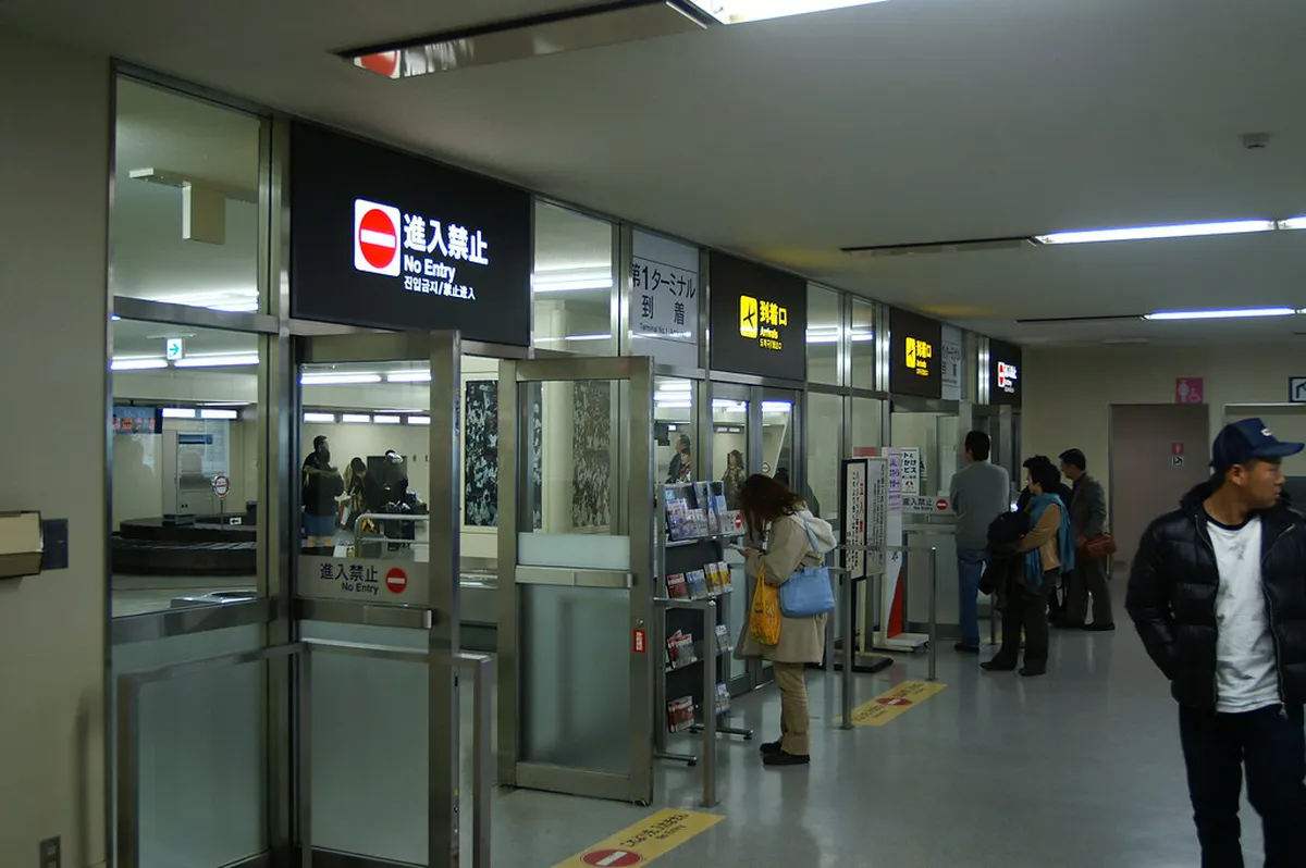 Interior view of Fukuoka Airport terminal building showing departure and arrival signs for domestic and international flights in Japan
