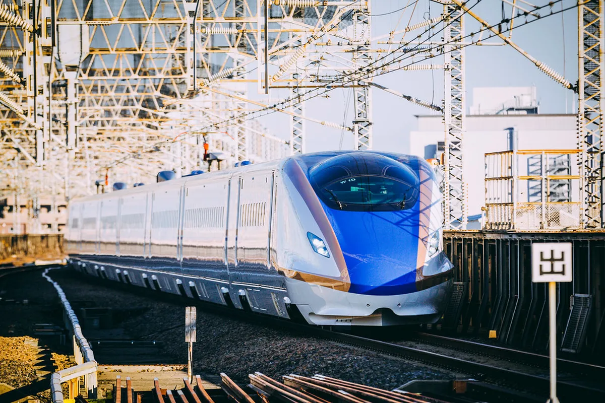 Hokuriku Shinkansen E7 series train at a Japanese station platform