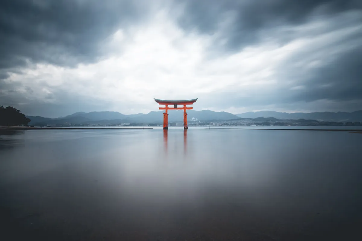 Miyajima Itsukushima Shrine iconic red Torii gate rising from the water in Hiroshima Bay, Japan