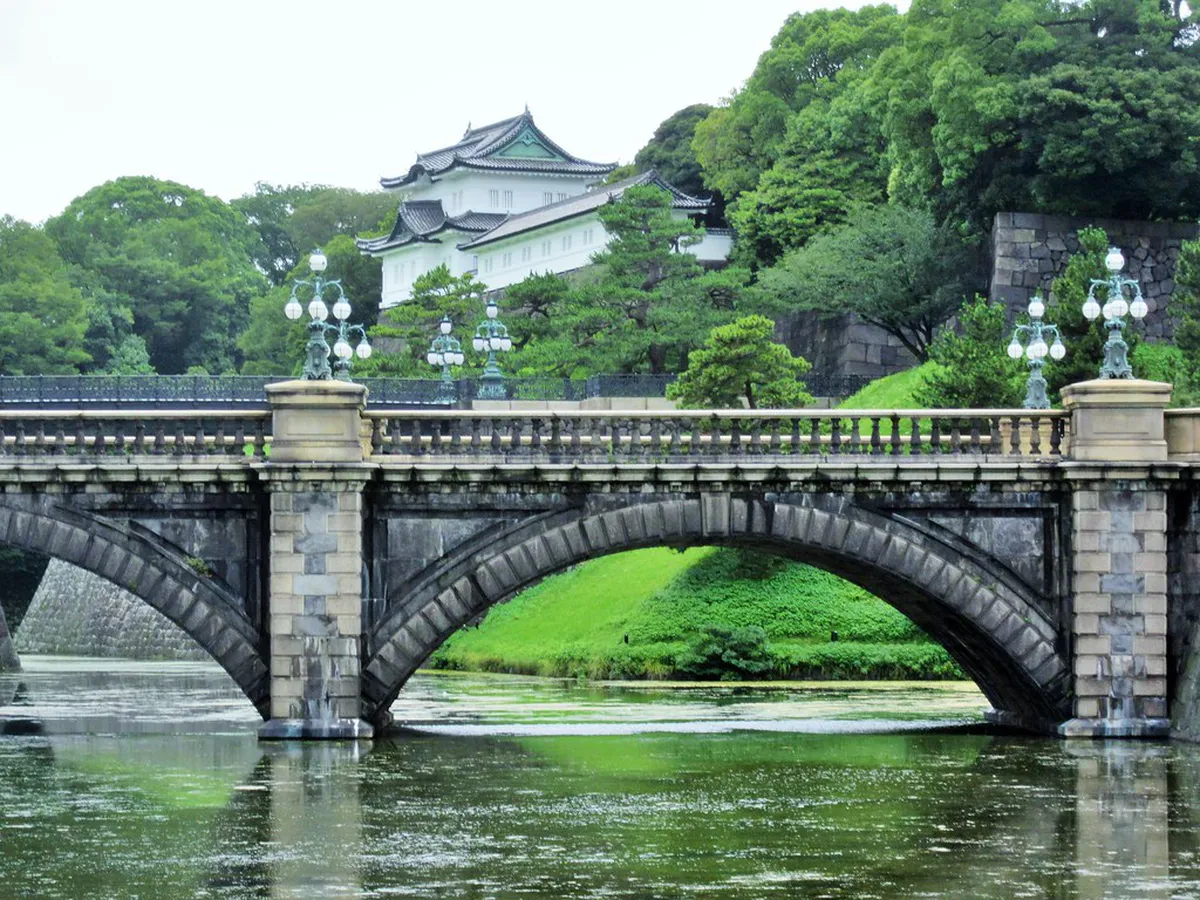 Nijubashi Double Bridge spanning the inner moat at Tokyo Imperial Palace with pine trees and stone walls in Japan