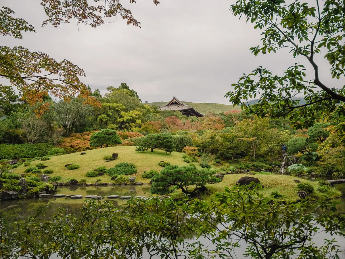Isuien Garden front pond with stone lanterns and traditional tea house reflected in calm water in Nara, Japan