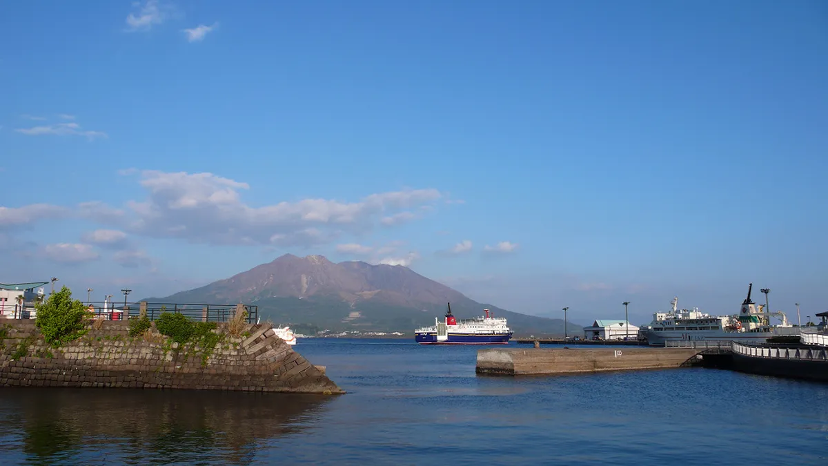 Kagoshima waterfront boardwalk with Sakurajima volcano across Kinko Bay visible in the background Japan
