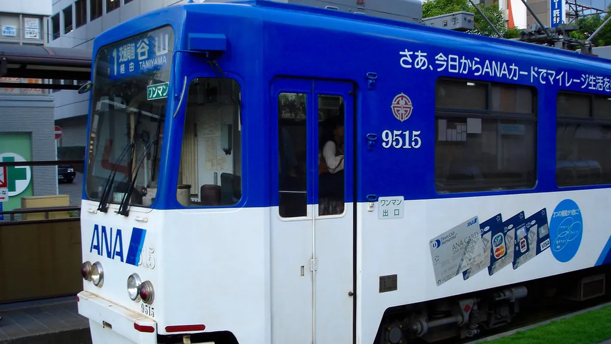 Kagoshima city tram streetcar running through the downtown district in Kagoshima, Japan