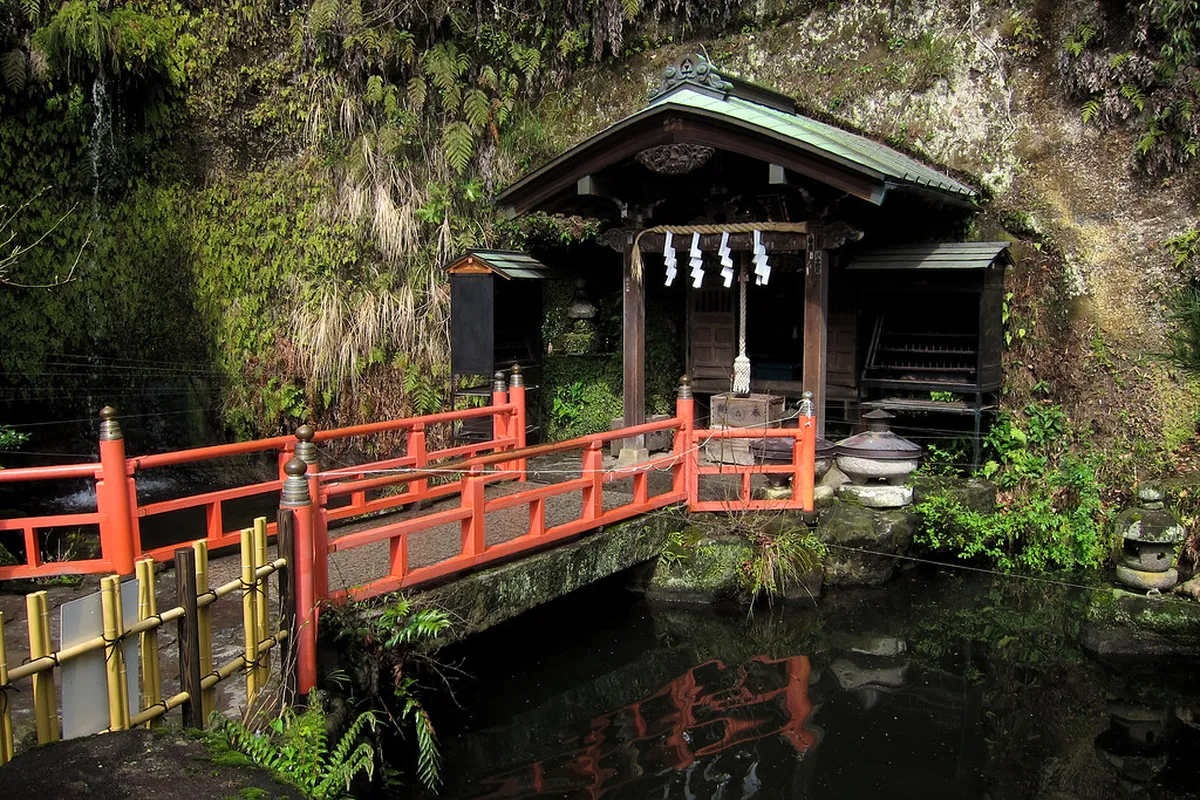 Zeniarai Benten shrine cave passage in Kamakura Japan with lanterns and ritual offerings at the sacred spring
