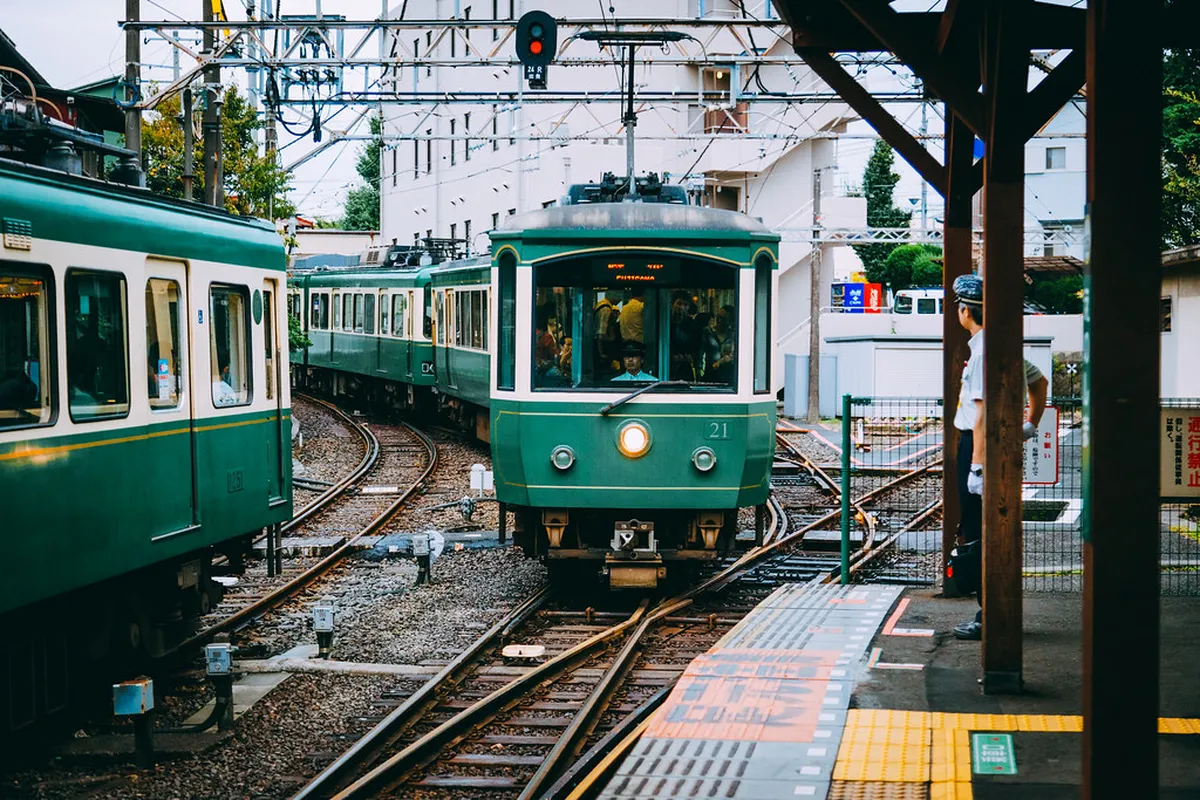 Kamakura station platform with JR train arriving on a bright day in Japan ready for day trippers from Tokyo