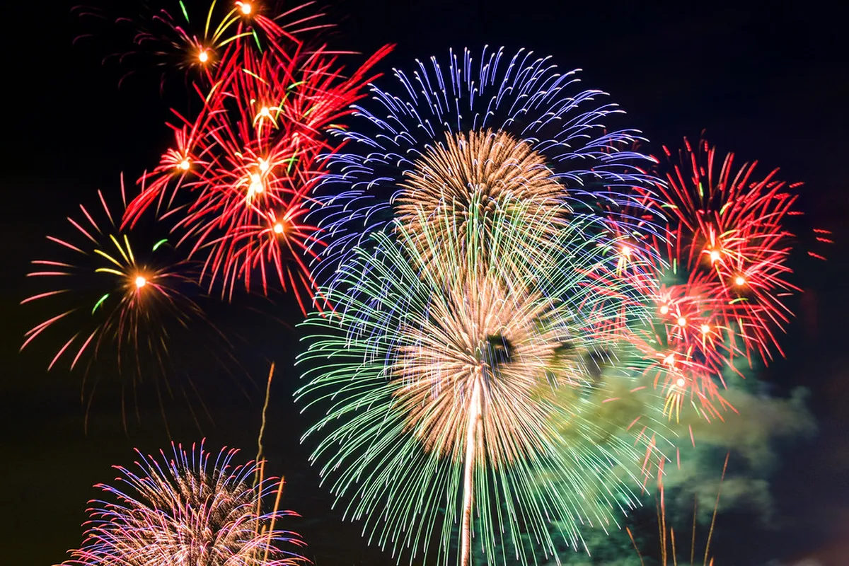 Brilliant fireworks exploding over a beach in Japan during a summer festival mirroring the Kamakura display
