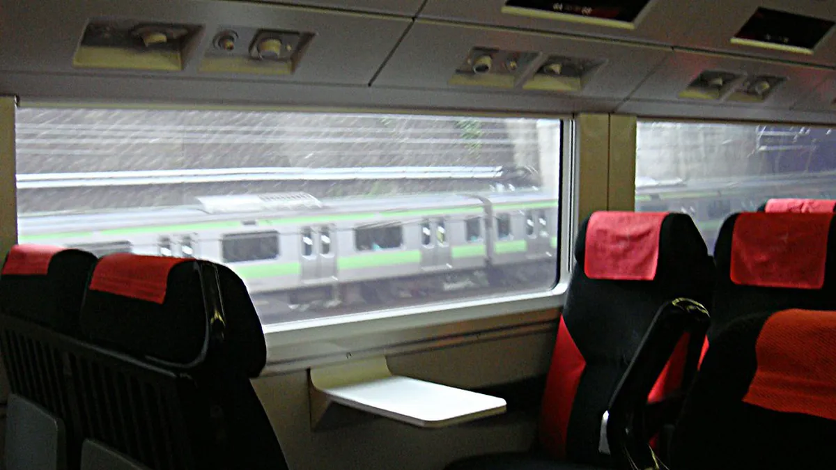 JR train at a station platform in Japan with passengers ready for the scenic ride from Tokyo to Kamakura