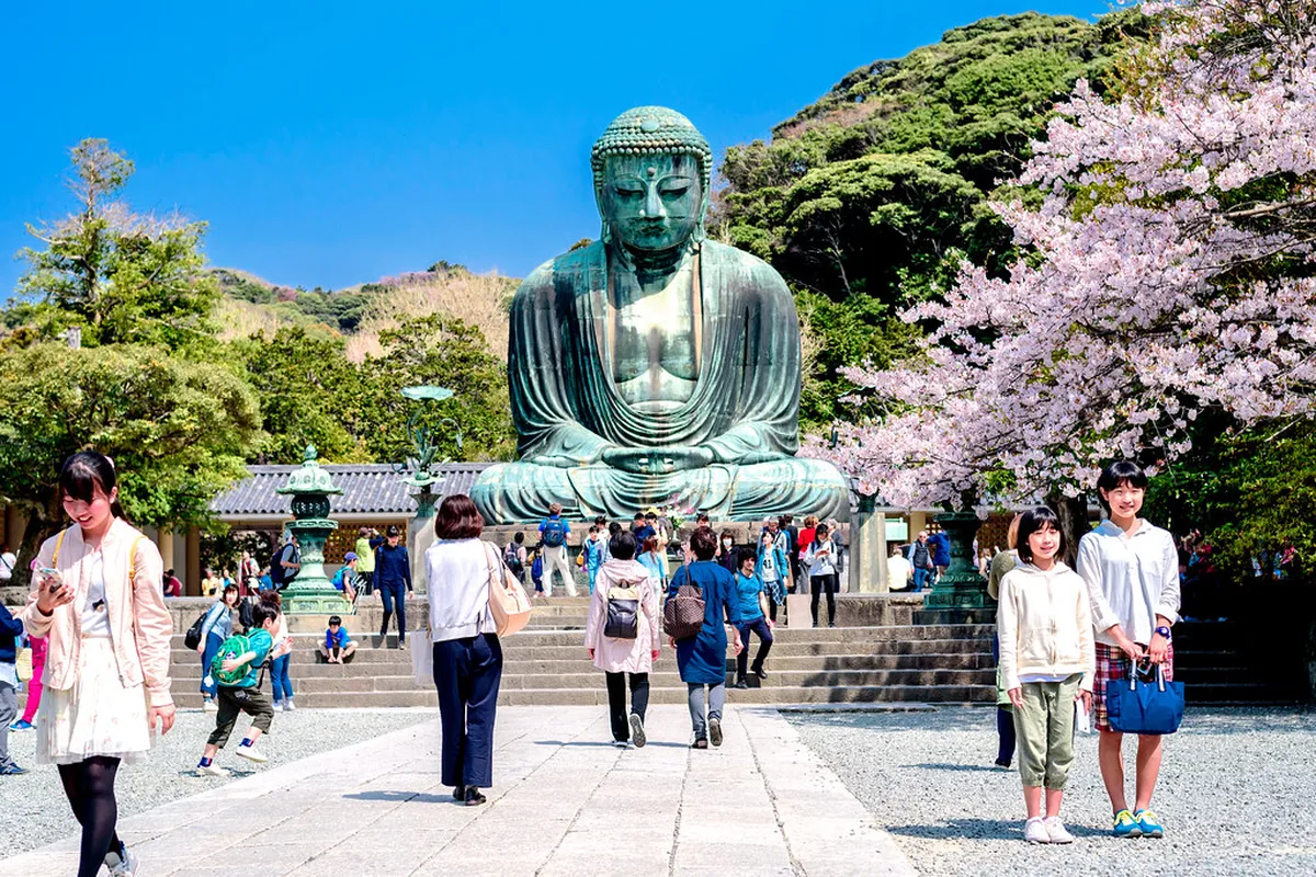 The massive bronze Great Buddha statue at Kotoku-in Temple sitting peacefully in the open air in Kamakura, Japan