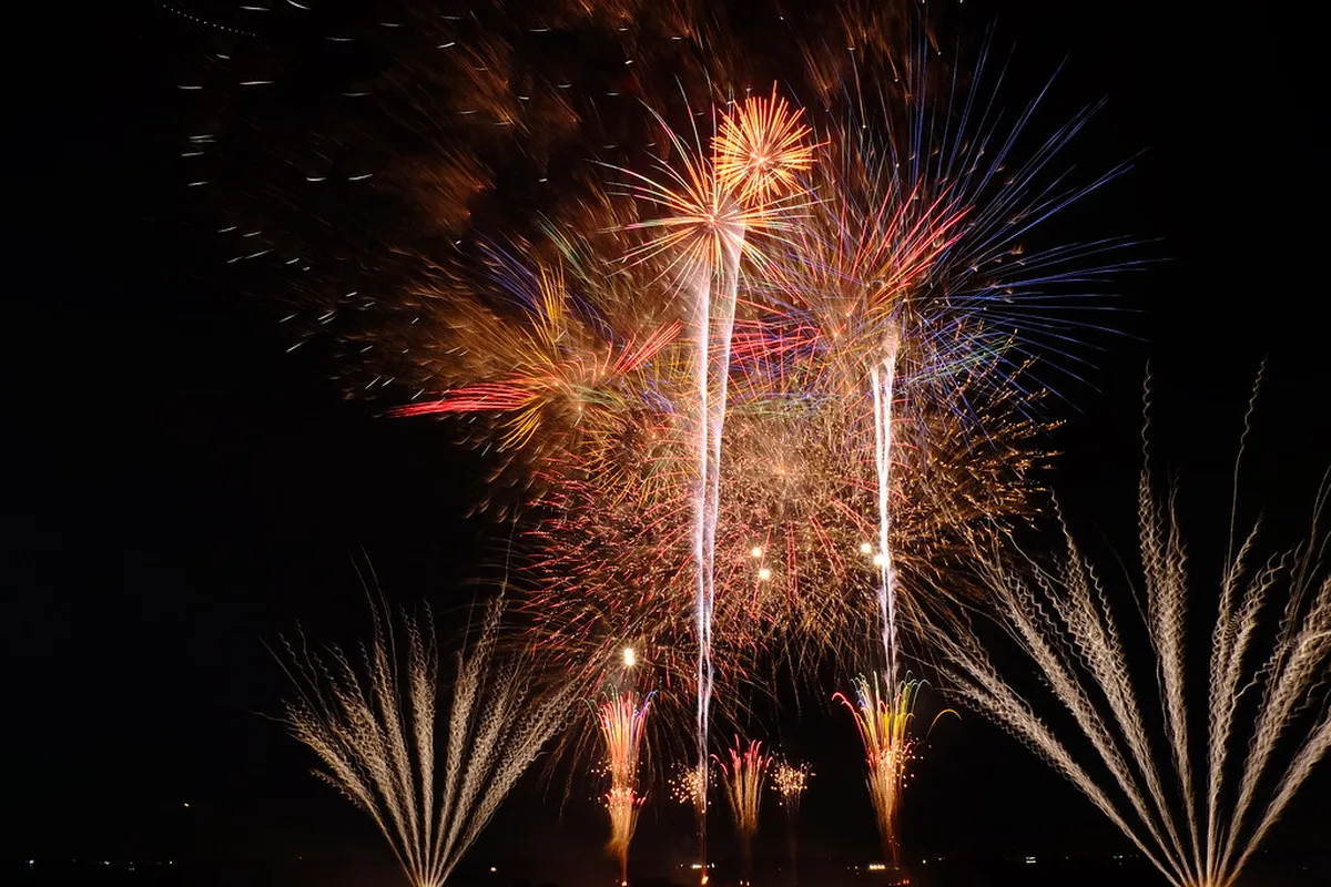 Japanese summer fireworks display over a river at a matsuri festival