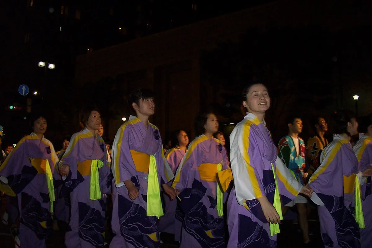 Colorful participants in traditional samurai armor and period costume marching through the streets of Kanazawa, Japan during the Hyakumangoku Festival parade